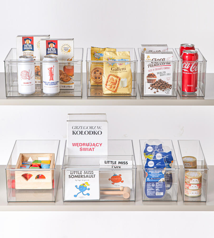 The KLAR storage containers with compartments from BNB x VCN (extra long, various sizes) keep boxes, cans, snacks, toys, and books neatly and clearly organized on two shelves.