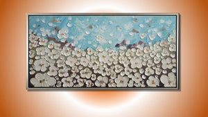 Handgemaltes Ölbild weisse Blütenwiese auf Leinwand, reliefartige Spachtelblüten unter hellblauem Himmel, mit silbernem Rahmen – Beispiel im Raum