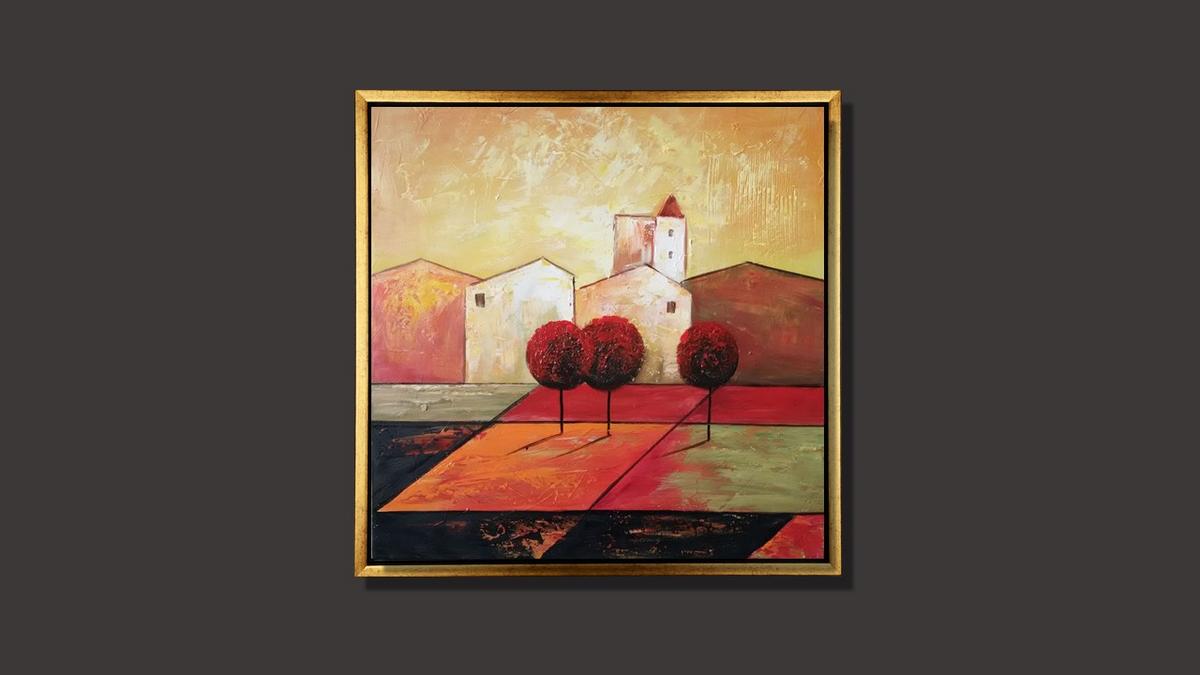 Handgemaltes Ölbild mediterranes Dorf mit roten Bäumen auf Leinwand, warme Rot-, Orange- und Goldtöne, mit goldenem Rahmen – Beispiel im Raum