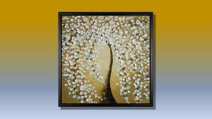 Handgemaltes Ölbild Baum mit weissen Blüten auf Leinwand, Spachtelrelief auf goldenem Hintergrund, mit schwarzem Rahmen – Beispiel im Raum