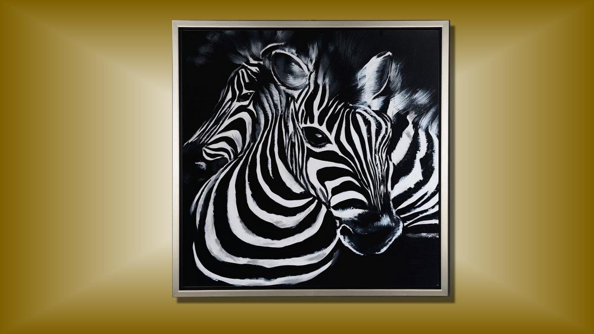 Handgemaltes Ölbild zwei Zebras auf Leinwand, grafische Schwarz-Weiss-Streifen vor schwarzem Hintergrund, mit silbernem Rahmen – Beispiel im Raum