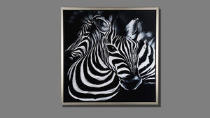 Handgemaltes Ölbild zwei Zebras auf Leinwand, grafische Schwarz-Weiss-Streifen vor schwarzem Hintergrund, mit silbernem Rahmen – Beispiel im Raum