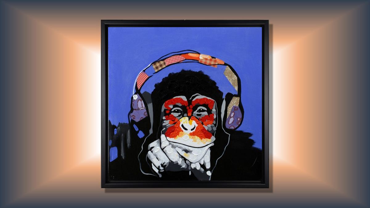 Handgemaltes Ölbild Affe mit Kopfhörern auf Leinwand, Pop-Art in Rot und Orange vor blauem Hintergrund, mit schwarzem Rahmen – Beispiel im Raum
