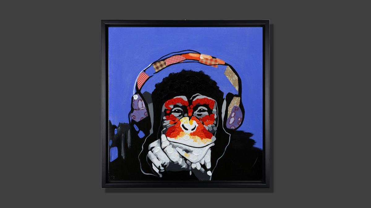 Handgemaltes Ölbild Affe mit Kopfhörern auf Leinwand, Pop-Art in Rot und Orange vor blauem Hintergrund, mit schwarzem Rahmen – Beispiel im Raum