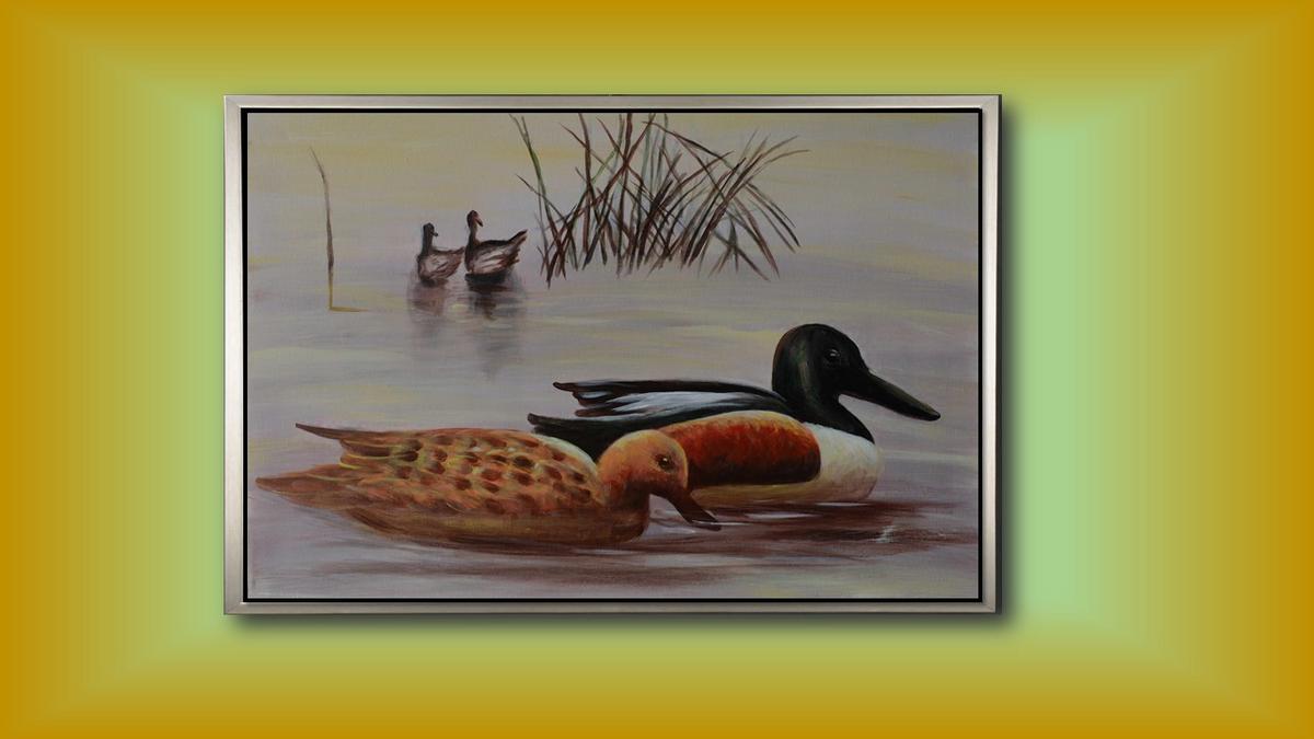 Handgemaltes Ölbild Enten am See auf Leinwand, Löffelentenpaar vor Schilf in zarten Grau- und Beigetönen, mit silbernem Rahmen – Beispiel im Raum