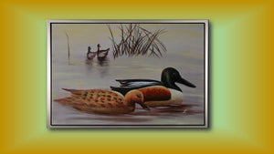 Handgemaltes Ölbild Enten am See auf Leinwand, Löffelentenpaar vor Schilf in zarten Grau- und Beigetönen, mit silbernem Rahmen – Beispiel im Raum