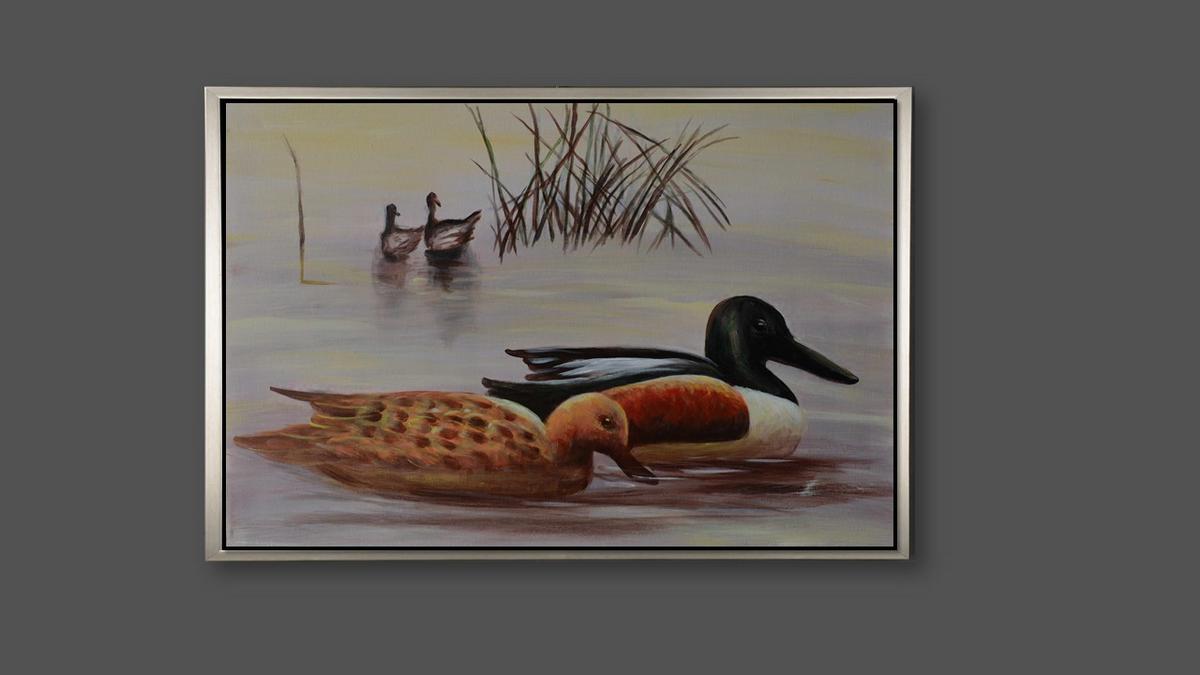 Handgemaltes Ölbild Enten am See auf Leinwand, Löffelentenpaar vor Schilf in zarten Grau- und Beigetönen, mit silbernem Rahmen – Beispiel im Raum