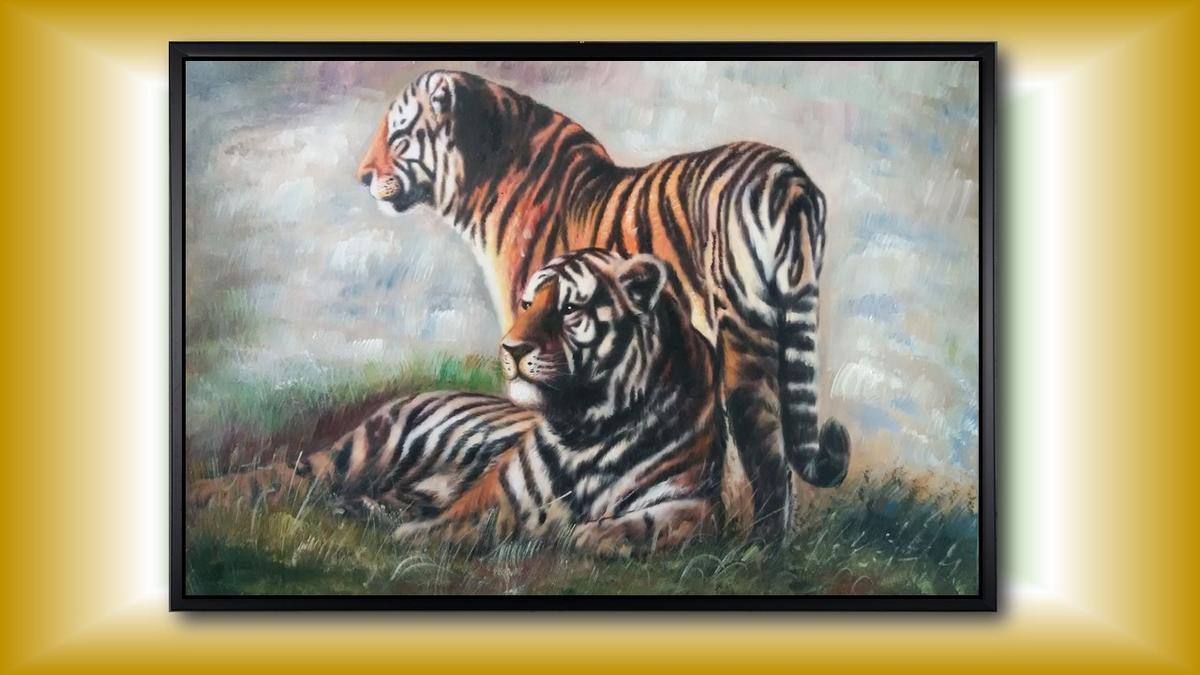 Handgemaltes Ölbild Tigerpaar auf Leinwand, stehender und liegender Tiger im Gras vor hellem Hintergrund, mit schwarzem Rahmen – Beispiel im Raum